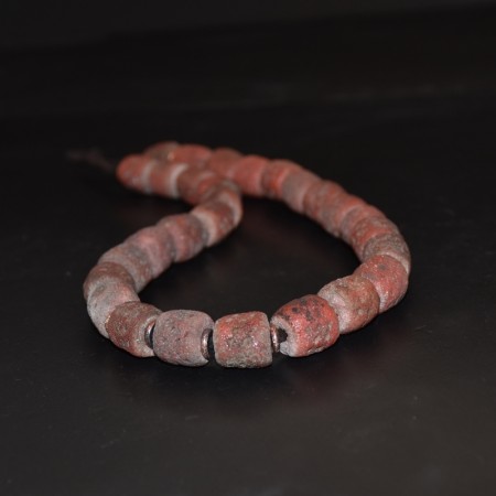 Strand with antique nigerian simulated coral glass beads