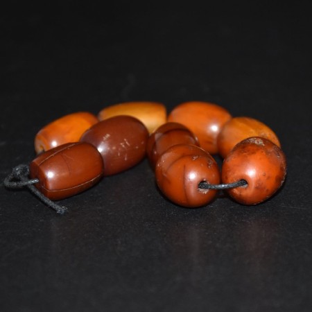 Strand with nine antique butterscotch simulated Amber / Faturan Beads