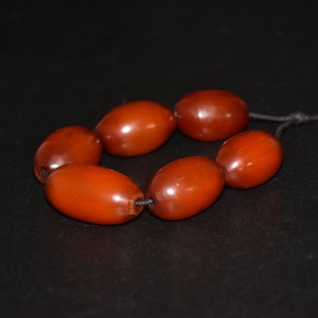 Six antique dark butterscotch simulated amber beads