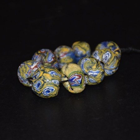 Group of nine antique yellow Venetian Eye Glass Beads